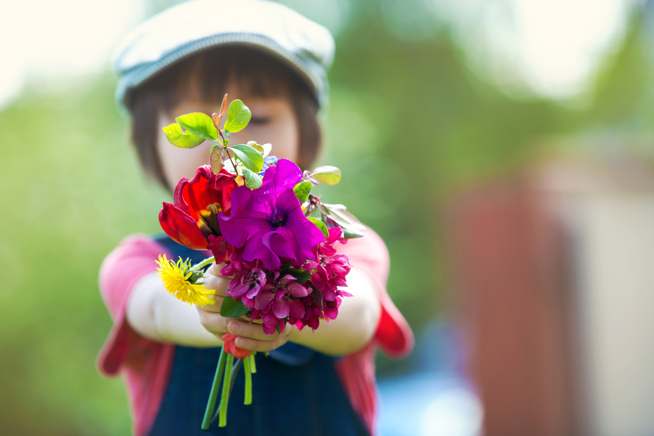 Preschool child, holding bouquet of wild flowers, gathered for mom. Mothers day concept