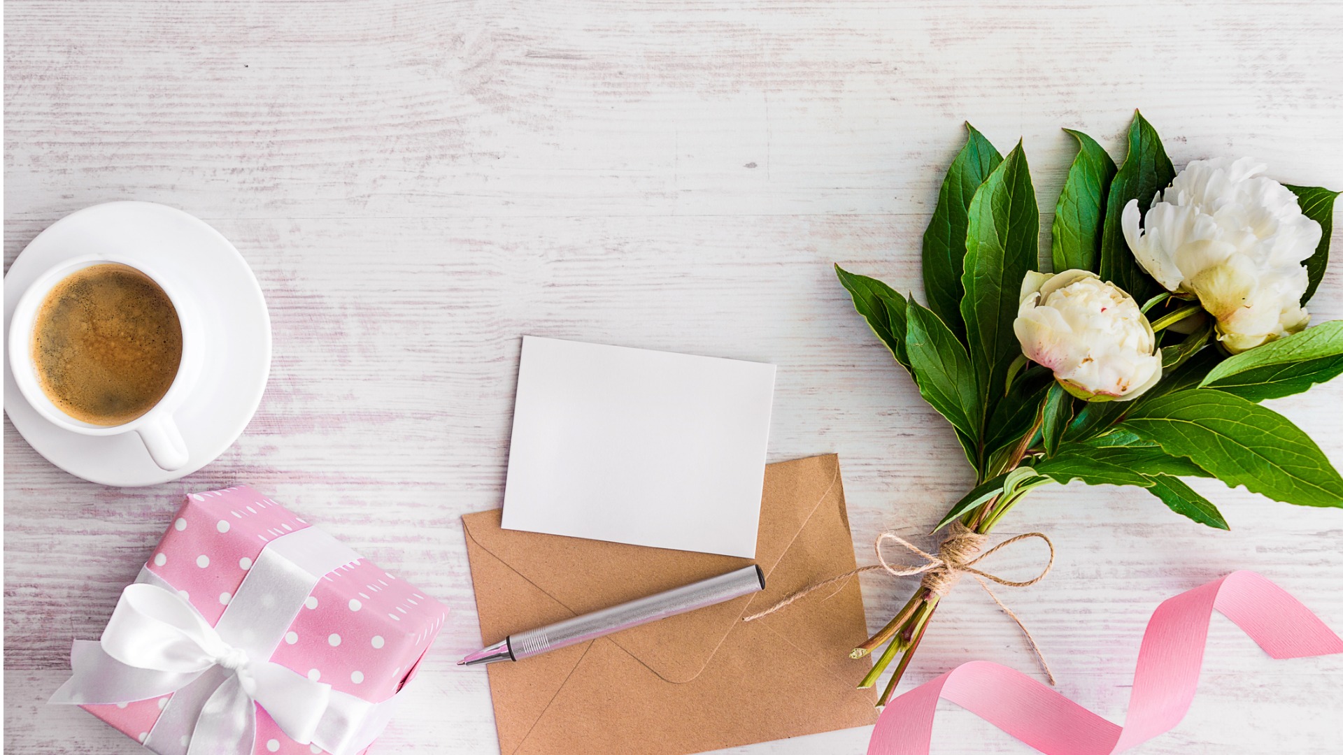 top-view-of-blank-note-envelope-coffee-cup-and-peonies-picture-id692711534